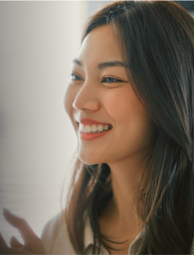 Profile view of a smiling woman with long dark hair.